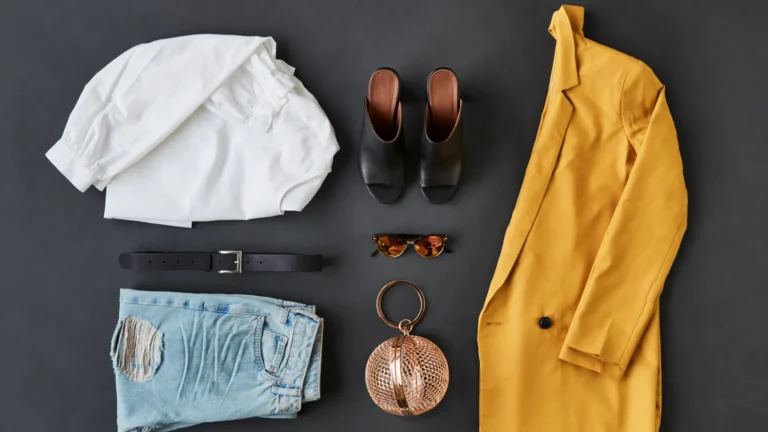 Fashionable outfit flat lay on dark background.