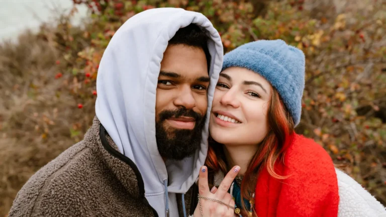 Lovely young multiethnic couple cuddling at the beach learned how to style a hoodie for a first date.