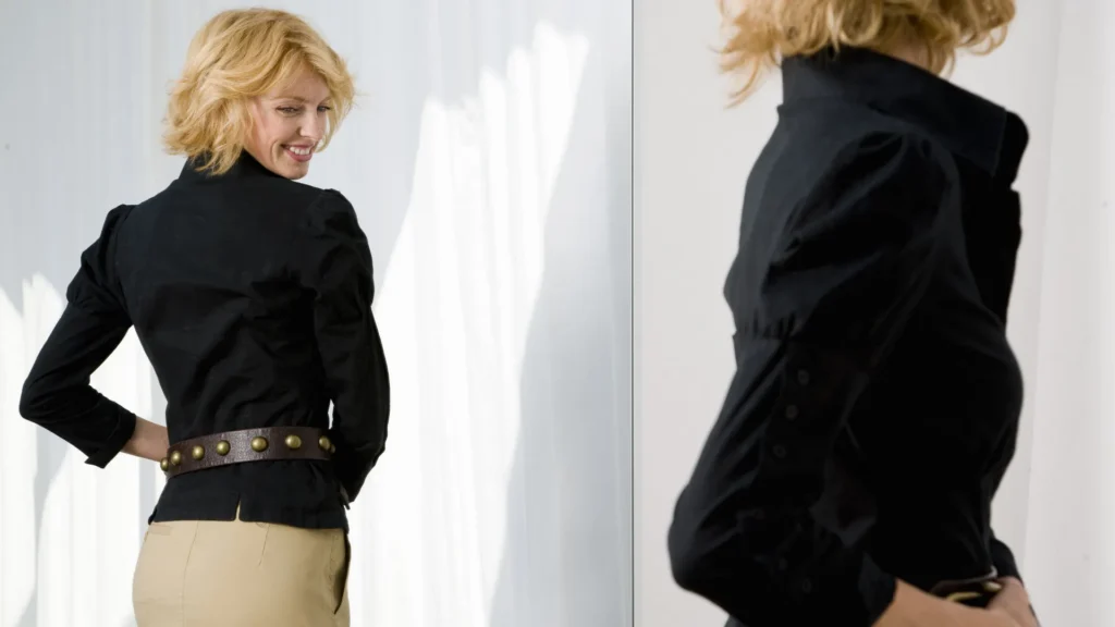 Woman in black shirt and tan skirt posing.